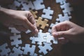 Two women are trying to connect a pair of puzzle pieces. Symbol of association and connection. Concept of business strategy Royalty Free Stock Photo