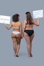 Two women in underwear with posters standing back. Royalty Free Stock Photo