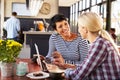 Two women using laptop computer in a coffee shop