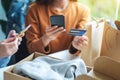 Two women using mobile phone and credit card for online shopping with shopping bag and postal parcel box of clothing Royalty Free Stock Photo