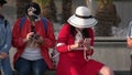 Two women using their smarphones while sitting outdoors.