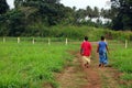 Two women walk at gravel road