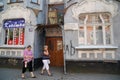 Two women walk near an old German house.