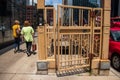 Two women walk past an open gate leading to stairwell to lower Wacker, ornately decorated with Chicago`s municipal device, the Y,