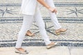 Two women walking in a typical Portuguese street paved in little stone Portugal Royalty Free Stock Photo