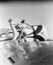 Two women walking on the wing of a plane