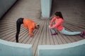 Two women warming up together and preparing for a morning run in an urban environment. Selective focus Royalty Free Stock Photo