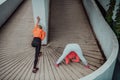 Two women warming up together and preparing for a morning run in an urban environment. Selective focus Royalty Free Stock Photo