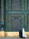 Two women wearing burqas walk past the Blue Mosque in Mazar i Sharif, Afghanistan Royalty Free Stock Photo