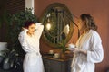 Two women in white robes drinking tea after spa treatments Royalty Free Stock Photo