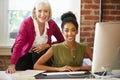 Two Women Working At Computer In Contemporary Office