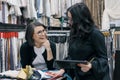 Two women working with interior fabrics digital tablet in showroom for curtains and upholstery fabrics, designer and buyer Royalty Free Stock Photo