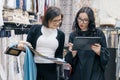 Two women working with interior fabrics digital tablet in showroom for curtains and upholstery fabrics, designer and buyer Royalty Free Stock Photo