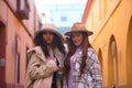 Two women, young and beautiful, wearing hats and coats, posing looking at the camera happy and relaxed. Concept beauty, fashion, Royalty Free Stock Photo