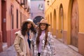 Two women, young and beautiful, wearing hats and coats, posing looking at the camera happy and relaxed. Concept beauty, fashion, Royalty Free Stock Photo