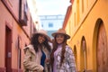 Two women, young and beautiful, wearing hats and coats, posing looking at the camera happy and relaxed. Concept beauty, fashion, Royalty Free Stock Photo