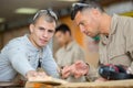 Two wood workers in carpentry measuring boards Royalty Free Stock Photo