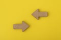 Two wooden arrows on yellow background. Direction signs. Copy space. Mock up Royalty Free Stock Photo