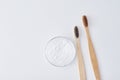 Two wooden bamboo toothbrushes and baking soda powder in glass jar on a pink background.  Teeth health and keep mouth concept Royalty Free Stock Photo