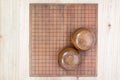 Two wooden bowls over empty go game board