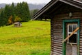 Two wooden cabins on a bright green meadow