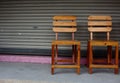 Two Wooden Chairs On Cement Floor With Roller Shutter Door At Behind Royalty Free Stock Photo