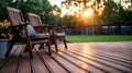 Two wooden chairs sitting on a wooden deck with a potted plant Royalty Free Stock Photo