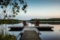 Two wooden chairs at Sunset on a pier on the shores of the calm Saimaa lakein Finland - 2