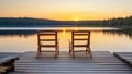 Two wooden chairs on a wood pier overlooking a lake at sunset Royalty Free Stock Photo