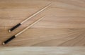 Two wooden chopsticks on a wooden table