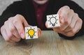 Two wooden cubes in the hands of a person in a suit, one of which is lit in yellow, which symbolizes the new idea, the concept of Royalty Free Stock Photo