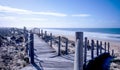 Two wooden decking pathways forming a fork in the road both heading down to a sandy beach Royalty Free Stock Photo