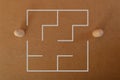 Two wooden doll figures standing at the entrance of a maze. Business strategy, solution, challenge and problem solving concept