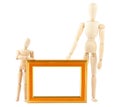 Two wooden dummy and empty frame Royalty Free Stock Photo