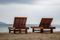 Two wooden empty deck chairs on the beach. Overcast Royalty Free Stock Photo
