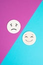 Two wooden faces one is sad the other one is smiling, positive and negative emotions, rating concept