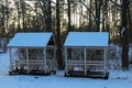 Two wooden gazebos for winter recreation in the winter forest. Wooden canopy with benches in the snow. Picturesque winter season Royalty Free Stock Photo