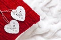 Two wooden heart shape decorations on the red pillow on the white blanket Royalty Free Stock Photo