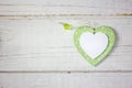 Two wooden hearts - white and green over the wooden background