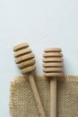 Two Wooden Honey Dippers Spoons on Burlap Cloth White Concrete Stone Table. Holiday Baking Cooking