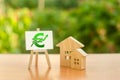Two wooden houses and a green Euro up arrow on the sign. Real estate value increase. Rising prices for housing, building Royalty Free Stock Photo