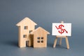 Two wooden houses and a poster with a symbol of falling value. concept of real estate value decrease. low liquidity Royalty Free Stock Photo