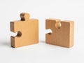 Two wooden jigsaw puzzle pieces on a light background Royalty Free Stock Photo