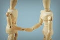 Two wooden mannequins shaking hands - Concept of peace