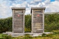 Two wooden outhouse toilets with red heart in mountain landscape. Royalty Free Stock Photo