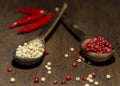 Two wooden spoons with red and white pepper on a wooden surface Royalty Free Stock Photo