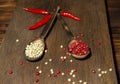 Two wooden spoons with red and white pepper on a wooden surface Royalty Free Stock Photo