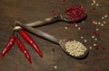 Two wooden spoons with red and white pepper on a wooden surface Royalty Free Stock Photo