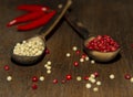 Two wooden spoons with red and white pepper on a wooden surface Royalty Free Stock Photo