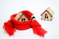 Two wooden toy houses on white background, one house weared on scarf, concept for insulation houses with copyspace Royalty Free Stock Photo